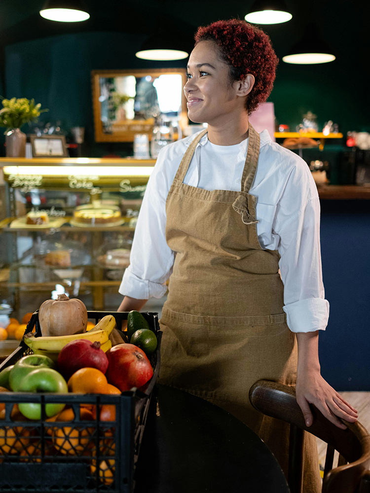 Young Canadian grocery store worker in produce section representing LMIA job advertising and employers hiring entry-level youth in Canada