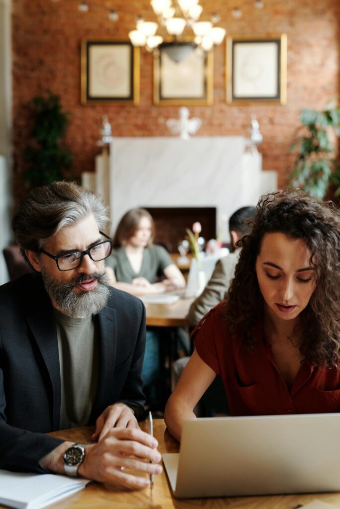 Immigration consultant reviewing workforce recruitment documents on computer with a young woman in Canada