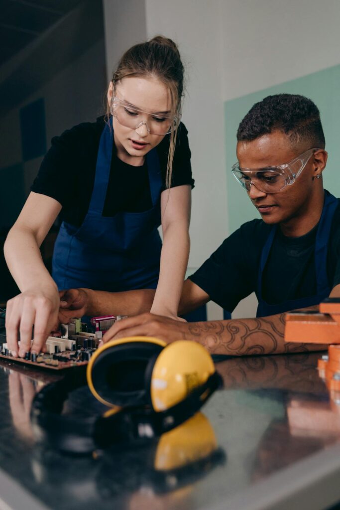 Two young workers operating and discussing machine development in a modern Canadian industrial workplace